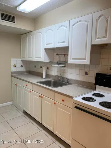 a kitchen with granite countertop a sink a stove and cabinets