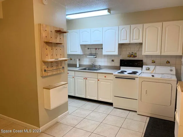 a kitchen with cabinets appliances a sink and a counter top space