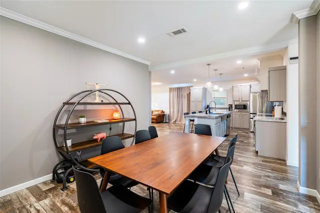 a kitchen with granite countertop a table chairs stainless steel appliances and cabinets