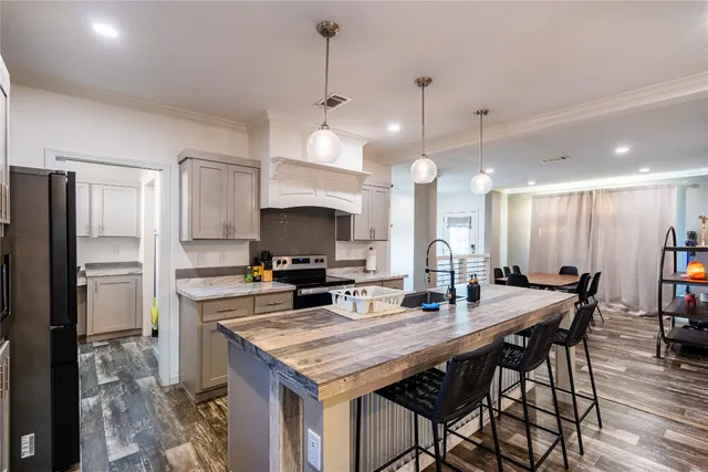 a kitchen with stainless steel appliances granite countertop a sink a stove and a wooden floors