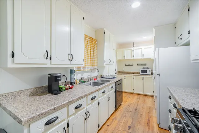 a kitchen with white cabinets and white appliances