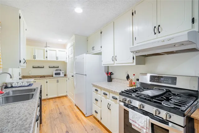 a kitchen with white cabinets and appliances