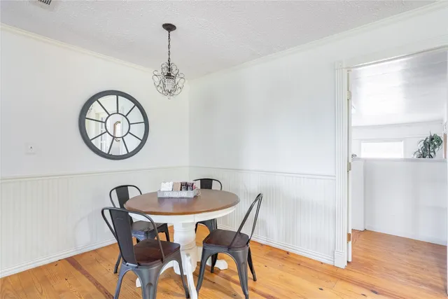 a view of a dining room with furniture wooden floor and a chandelier