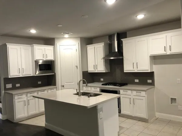 a kitchen with white cabinets sink and stainless steel appliances