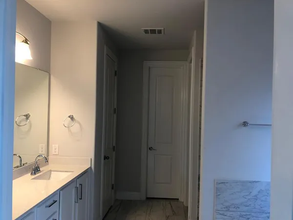 a bathroom with a granite countertop sink and a mirror