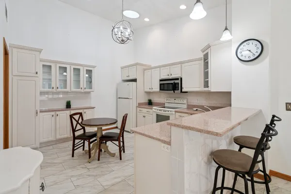 a view of kitchen with cabinets table and chairs