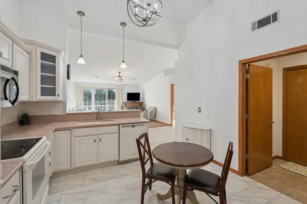 a kitchen with a table chairs sink and cabinets