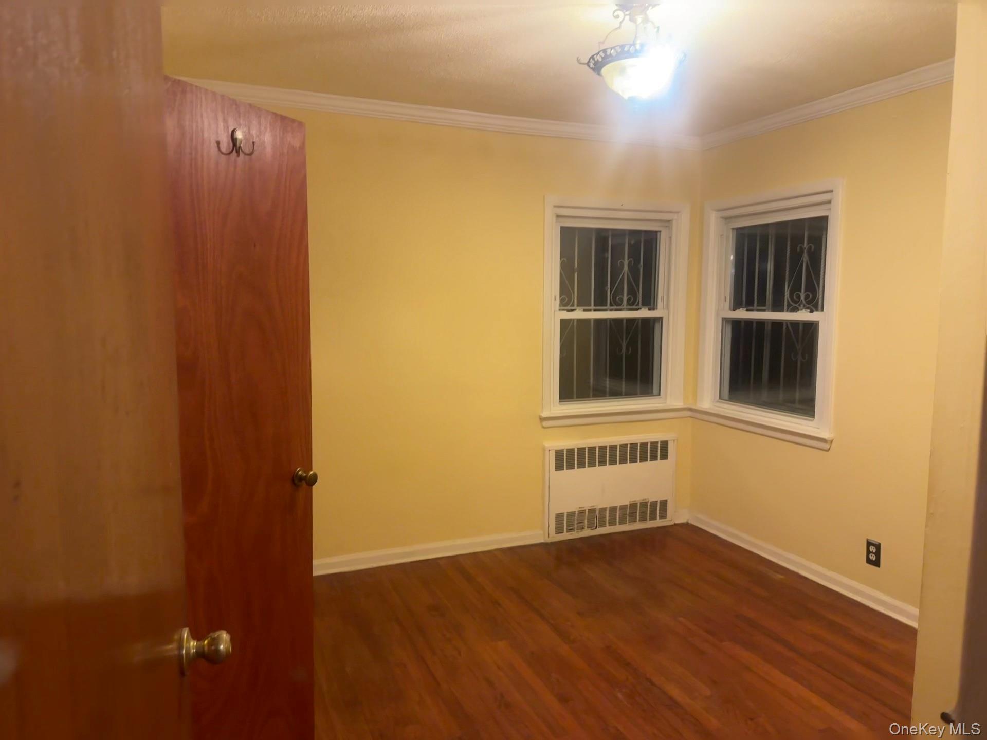 109-11 225th Street, Unit 1 Queens, NY 11429 - Photo 4 of 10 a view of an empty room with a window and wooden floor