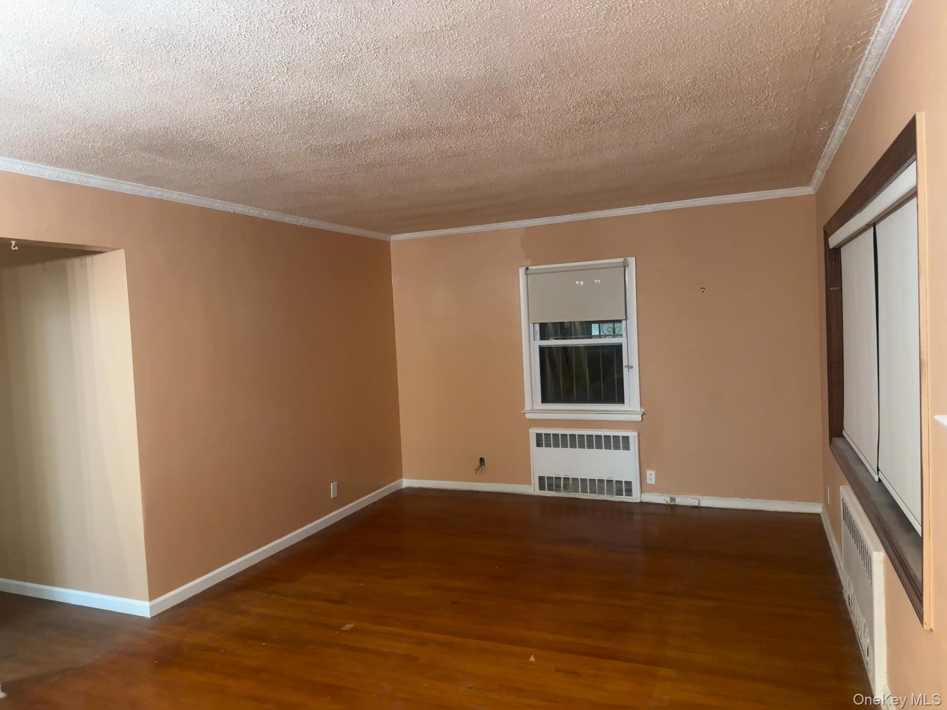 109-11 225th Street, Unit 1 Queens, NY 11429 - Photo 5 of 10 a view of an empty room with wooden floor and a window