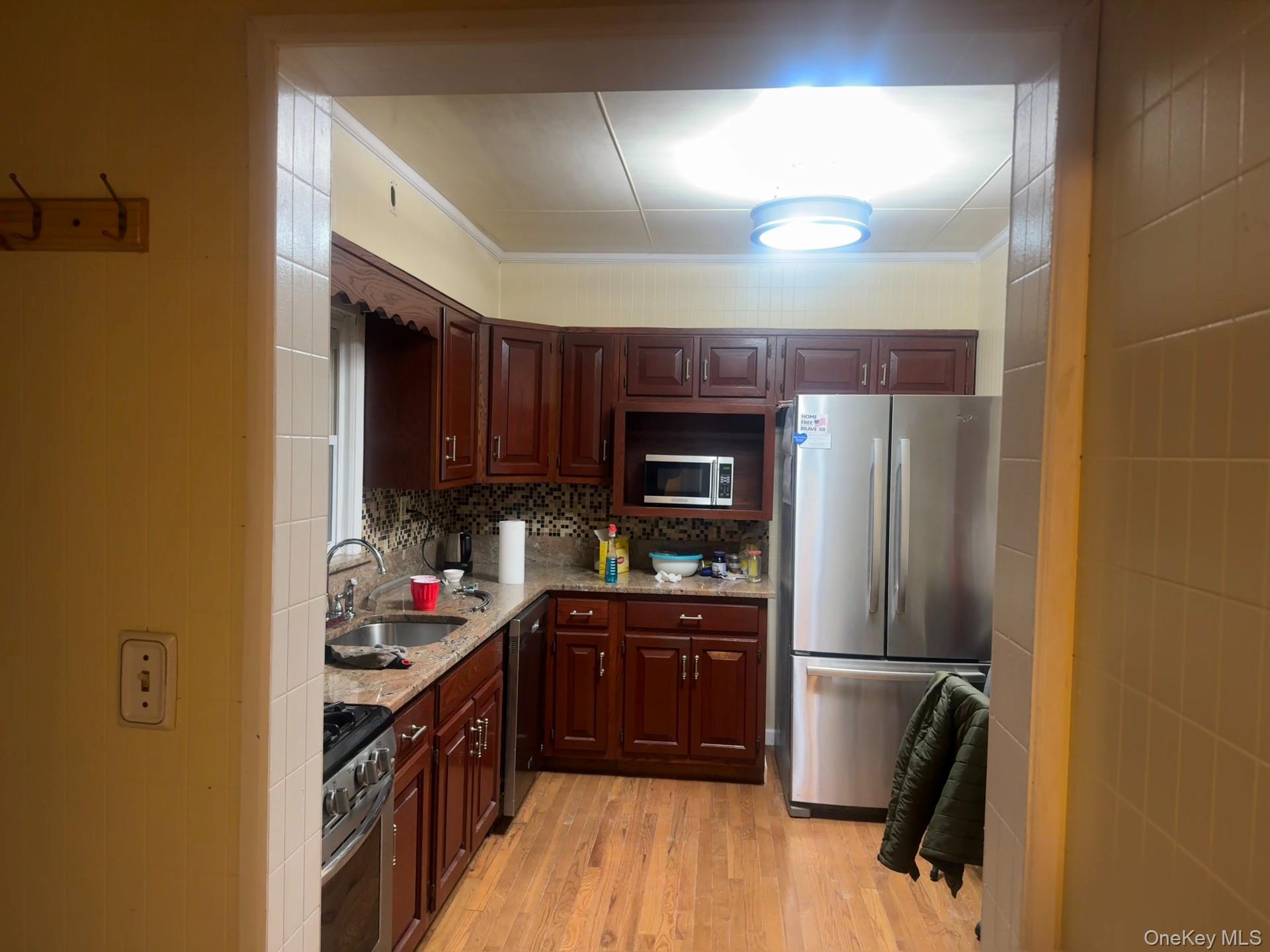 109-11 225th Street, Unit 1 Queens, NY 11429 - Photo 7 of 10 a kitchen with stainless steel appliances granite countertop a refrigerator and a stove top oven