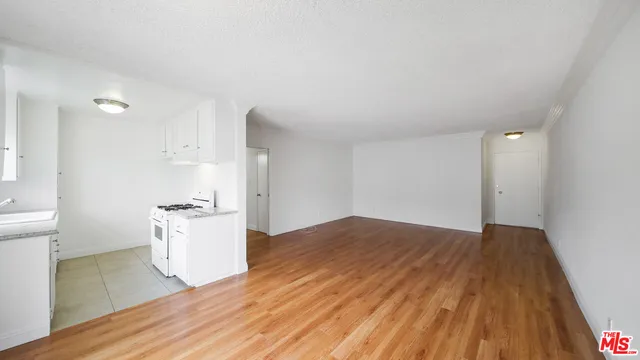 a kitchen with granite countertop a stove and a wooden floors
