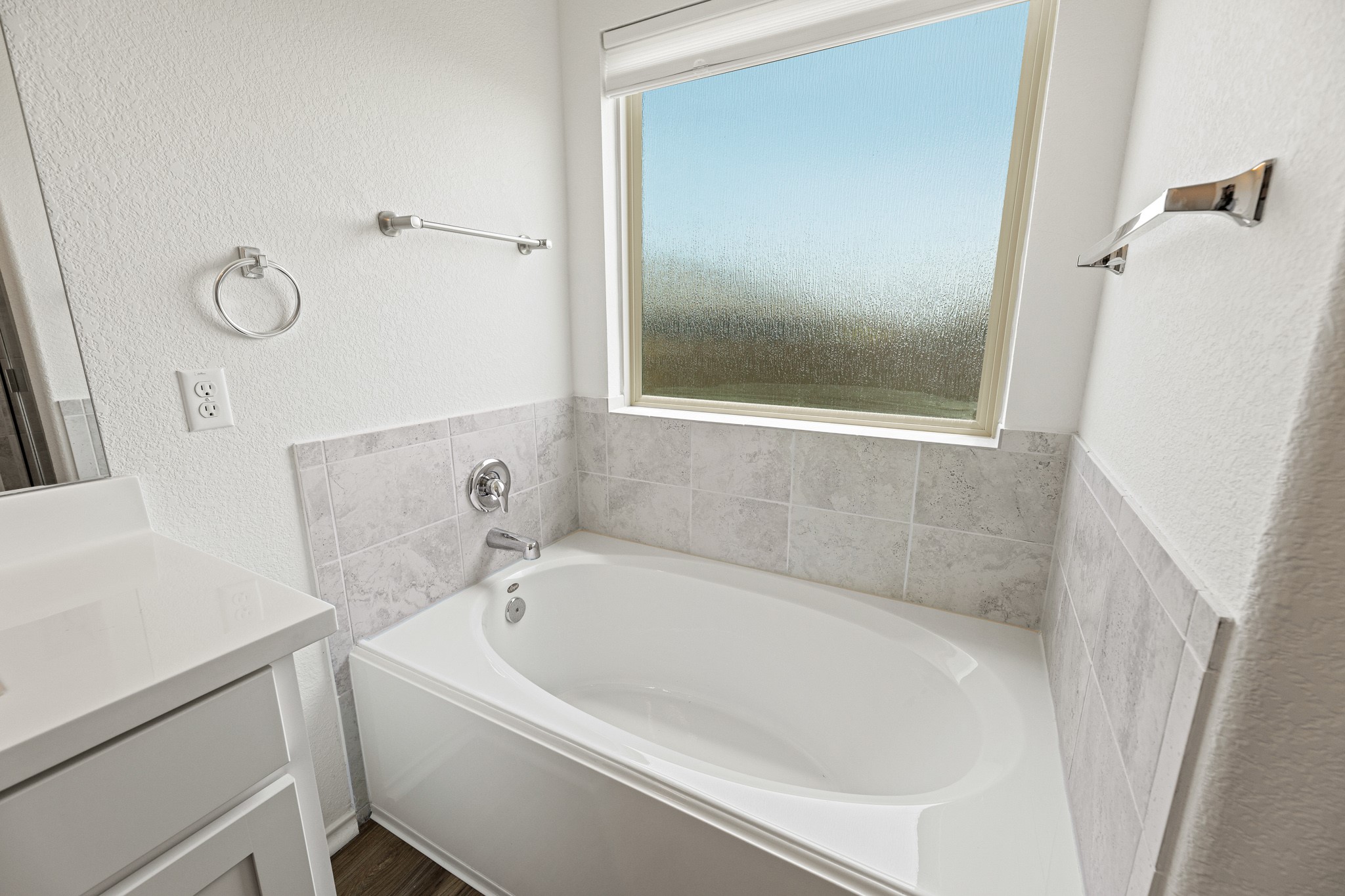21317 Resource Road Pflugerville, TX 78660 - Photo 18 of 37 A well-appointed bathroom features a deep soaking tub beneath a privacy-glass window, creating a serene personal retreat.