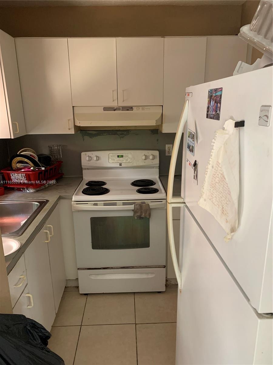 Allapattah Miami, FL 33142 - Photo 3 of 3 a white stove top oven sitting inside of a kitchen