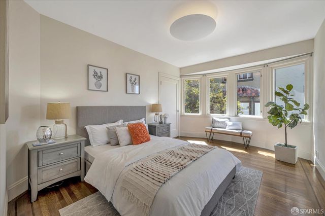 a bedroom with a bed and a painting on the wall