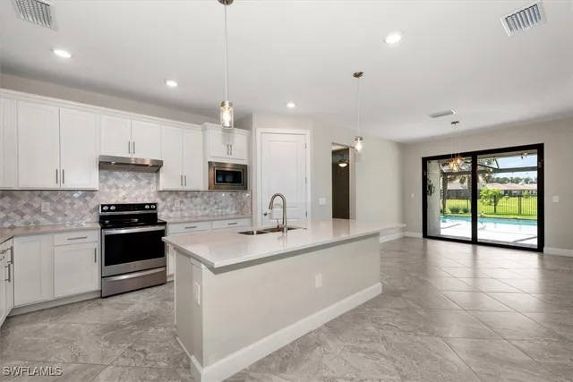 a kitchen with stainless steel appliances granite countertop a sink and cabinets