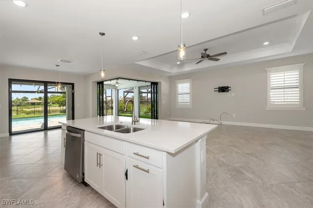 a view of a big room with windows and chandelier fan