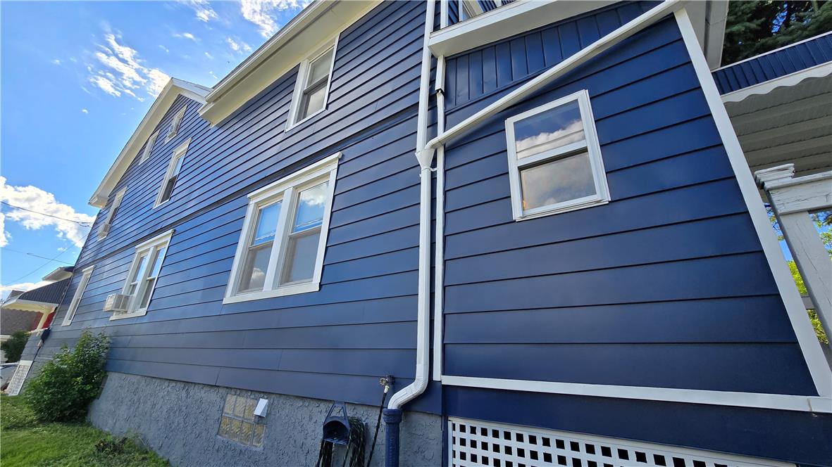 883 North Locust Street Hazleton, PA 18201 - Photo 39 of 83 Bold blue siding and white trim define this home's curb appeal, set against a bright sky.