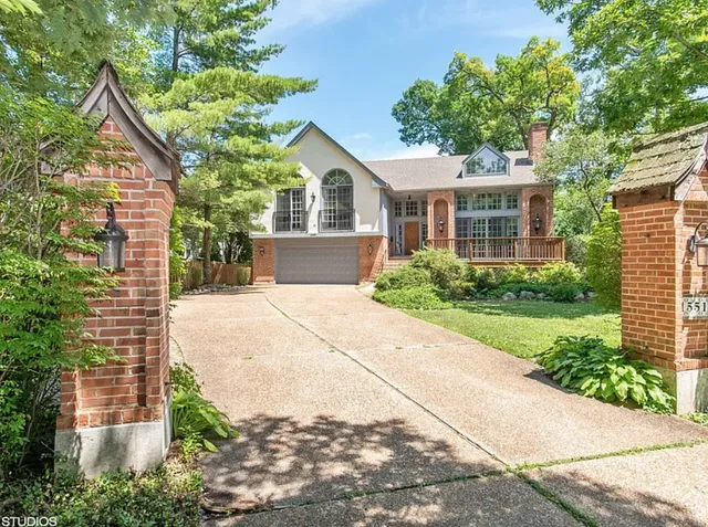 front view of a house with a yard and potted plants