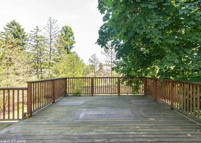 a view of a deck with a floor to ceiling window and wooden fence