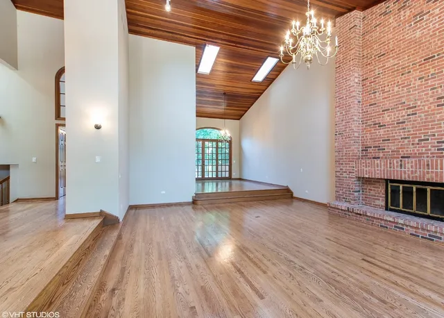 a view of empty room with wooden floor and fireplace