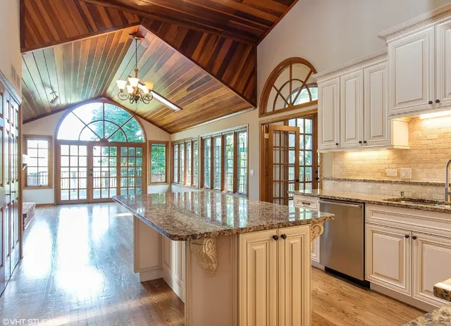 a kitchen with stainless steel appliances granite countertop a stove and a wooden floors
