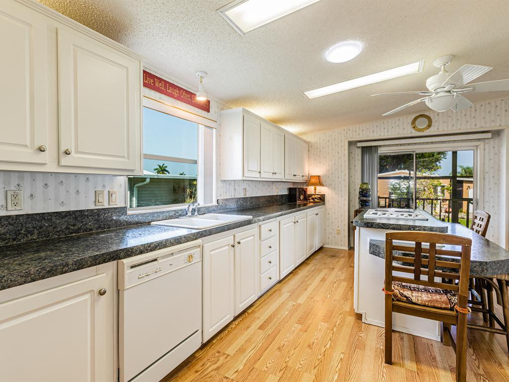 253 Riverwood Road Naples, FL 34114 - Photo 11 of 18 a kitchen with stainless steel appliances granite countertop a stove a sink and white cabinets