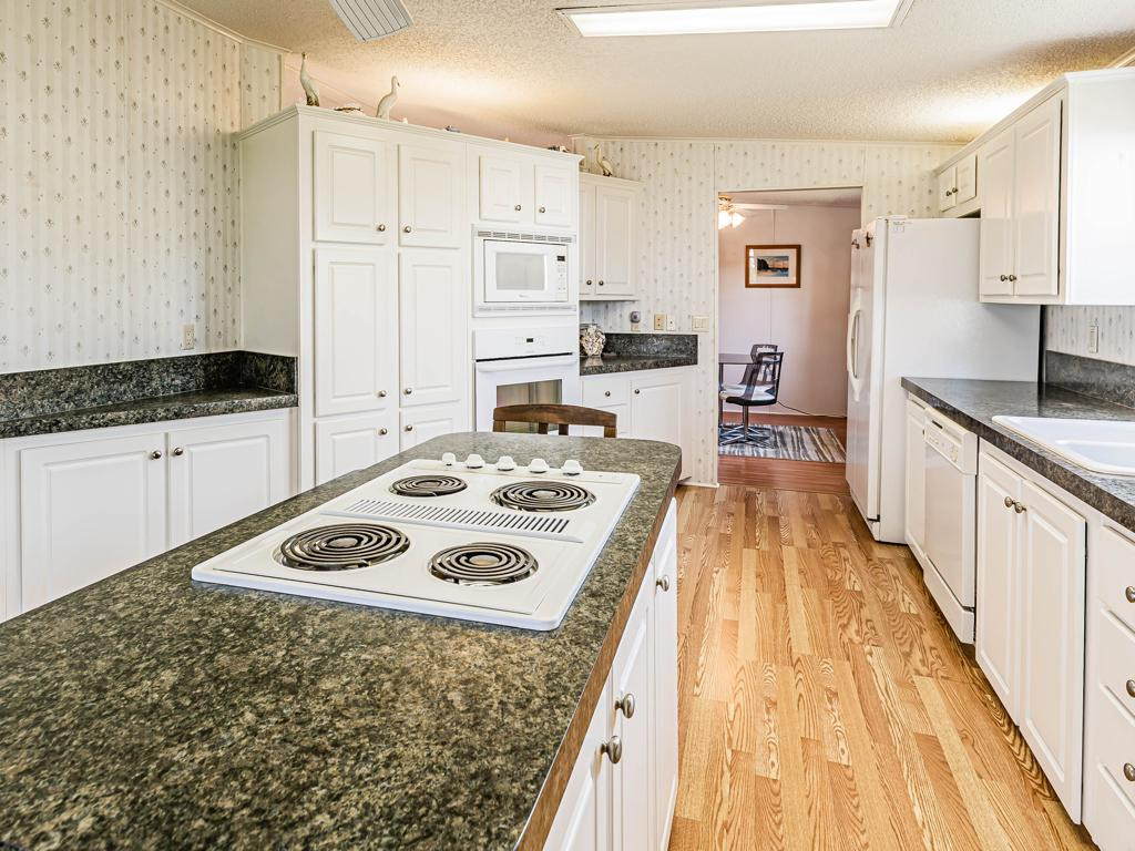 253 Riverwood Road Naples, FL 34114 - Photo 15 of 18 a kitchen with granite countertop a sink a stove top oven a counter space and cabinets
