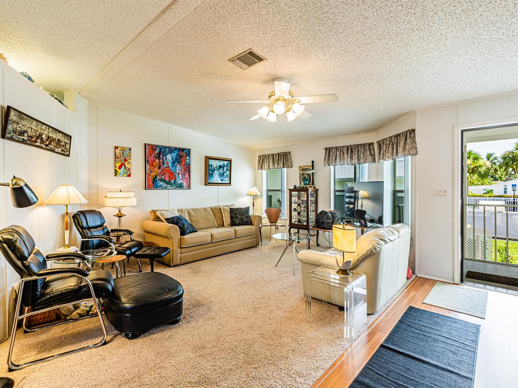 253 Riverwood Road Naples, FL 34114 - Photo 9 of 18 a living room with furniture and a chandelier