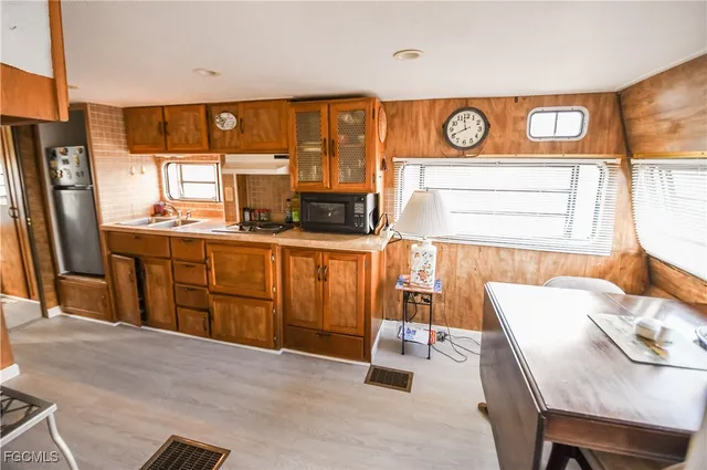 a kitchen with stainless steel appliances kitchen island granite countertop a refrigerator a stove a sink and dishwasher with wooden floor