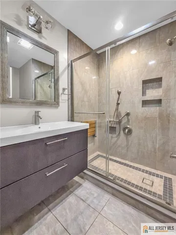 a bathroom with a sink a large mirror and a shower