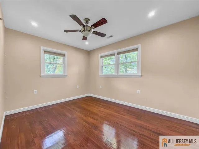 a view of a big room with wooden floor closet and windows