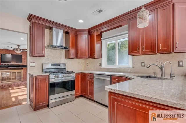 a kitchen with stainless steel appliances granite countertop a sink stove and cabinets