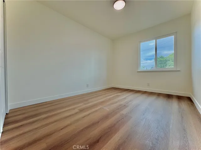 a view of a room that has wooden floor and window