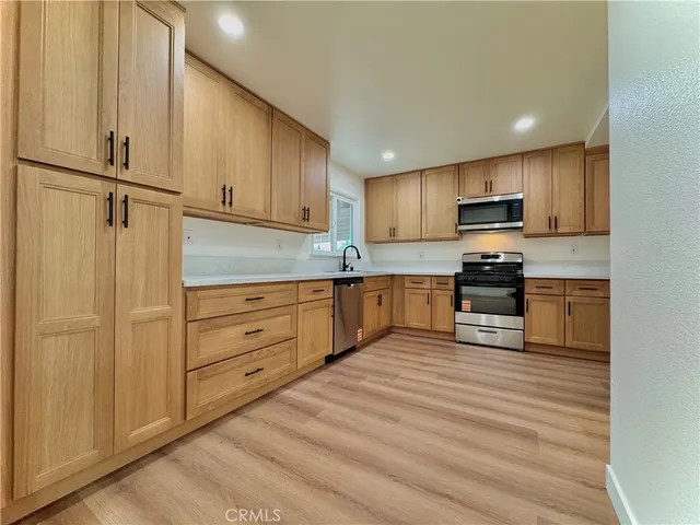 a kitchen with granite countertop white cabinets and stainless steel appliances