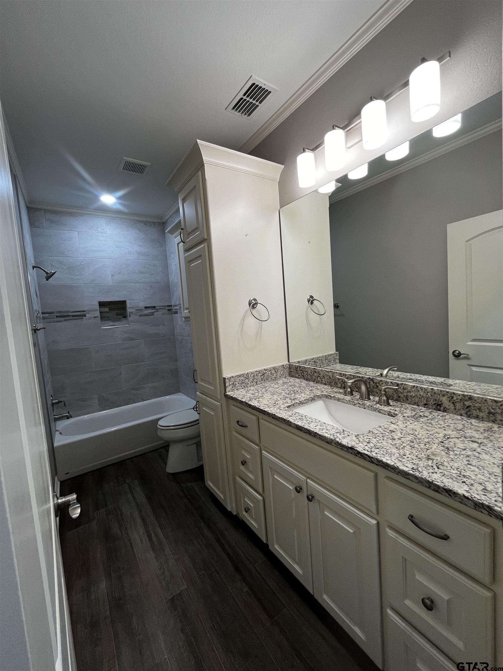 136 Letha Court Tyler, TX 75702 - Photo 25 of 34 a bathroom with a granite countertop sink a toilet and bathtub