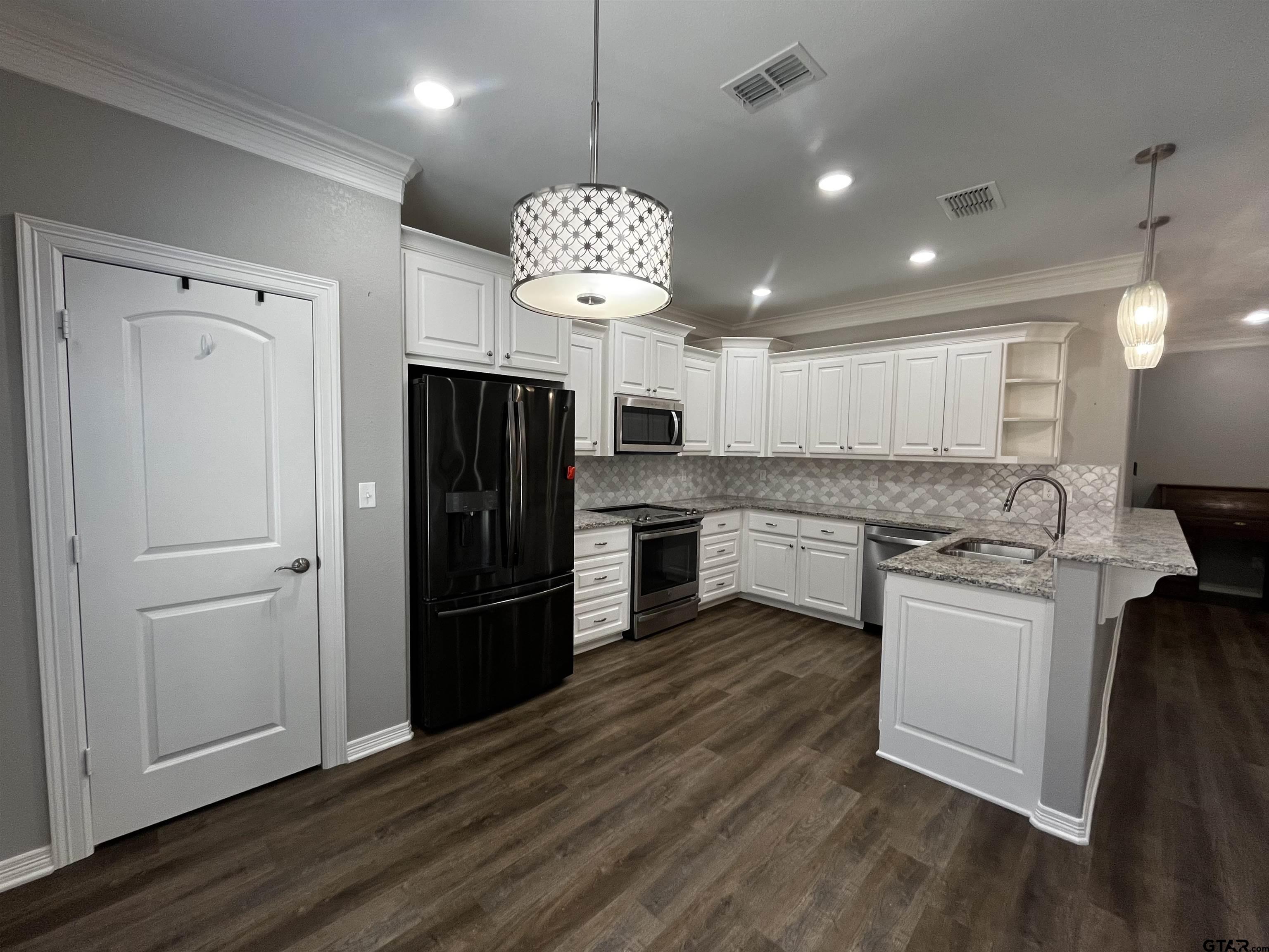 136 Letha Court Tyler, TX 75702 - Photo 7 of 34 a kitchen with a refrigerator a stove and a oven