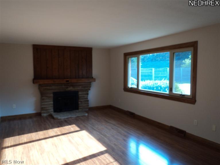 5690 Beach Road Medina, OH 44256 - Photo 8 of 14 FIREPLACED LIVING ROOM WITH NEW LAMINATE FLOORS AND WOOD STOVE INSERT IN WOODBURNING FIREPLACE.