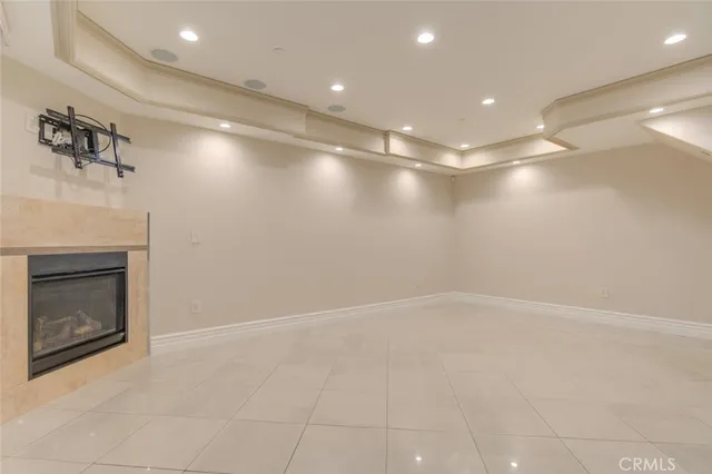 an empty room with windows and fireplace