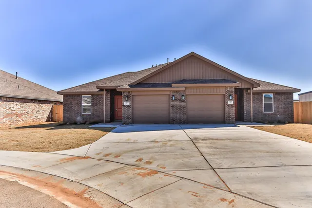 a front view of a house with yard and garage