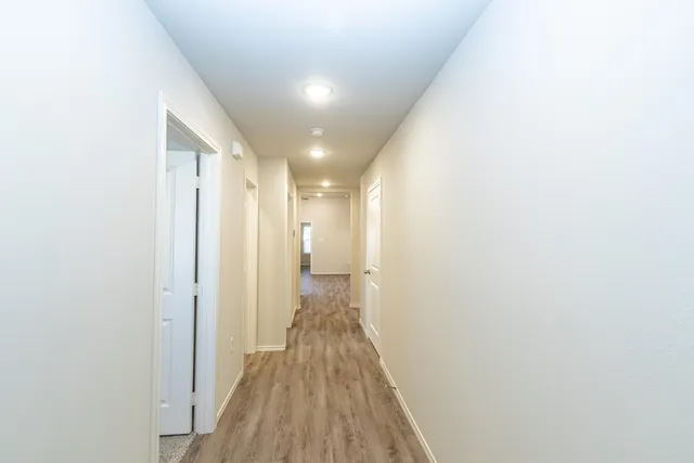 a view of hallway with wooden floor