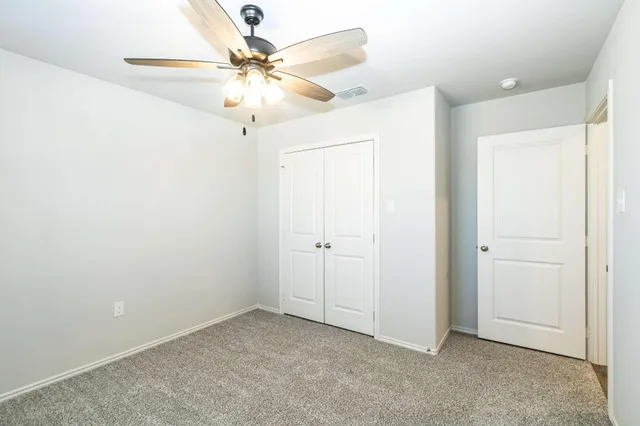an empty room with fan and entryway