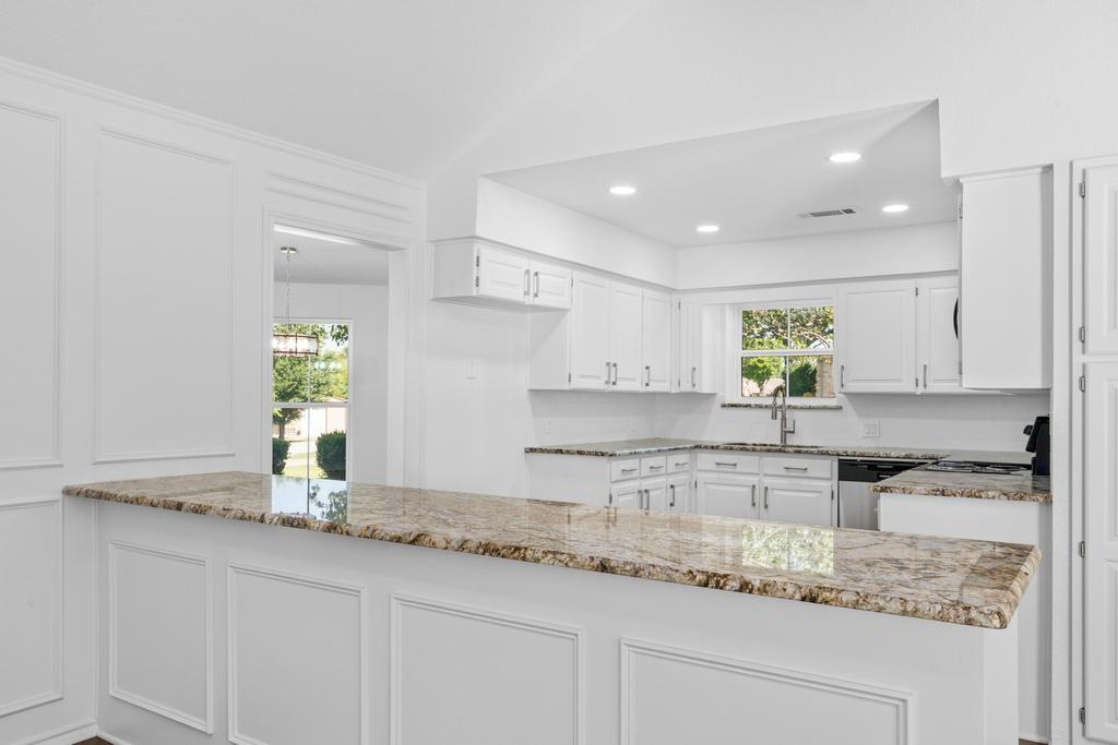 4501 Ridgeway Road Fort Worth, TX 76126 - Photo 14 of 39 a kitchen with granite countertop a sink stainless steel appliances white cabinets and a granite counter tops