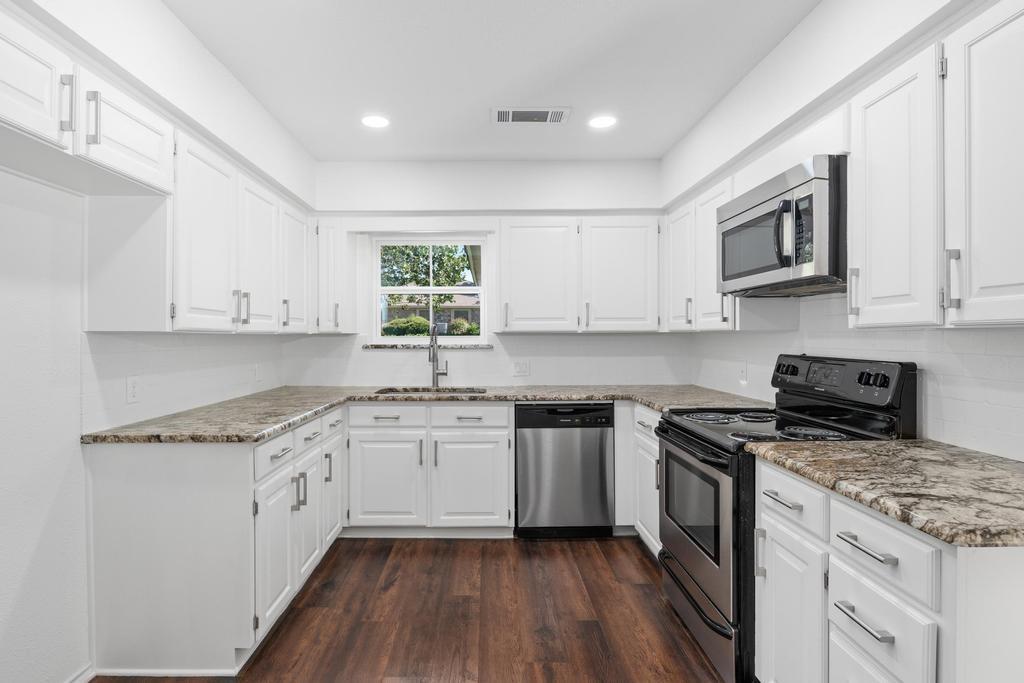 4501 Ridgeway Road Fort Worth, TX 76126 - Photo 15 of 39 a kitchen with stainless steel appliances granite countertop a stove a sink and a microwave