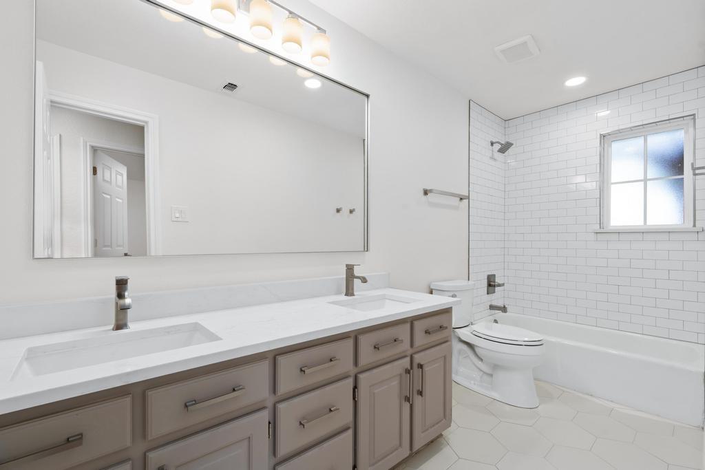 4501 Ridgeway Road Fort Worth, TX 76126 - Photo 24 of 39 a bathroom with a double vanity sink toilet and a mirror