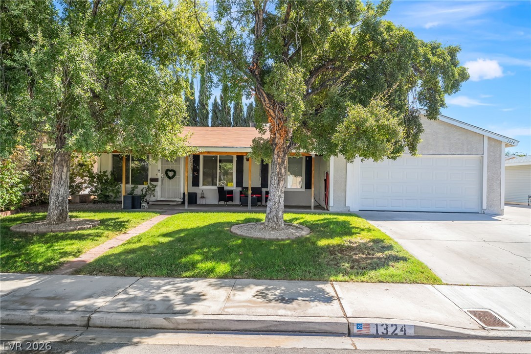 Mature trees shade the front lawn and walkway leading to this classic ranch-style residence.