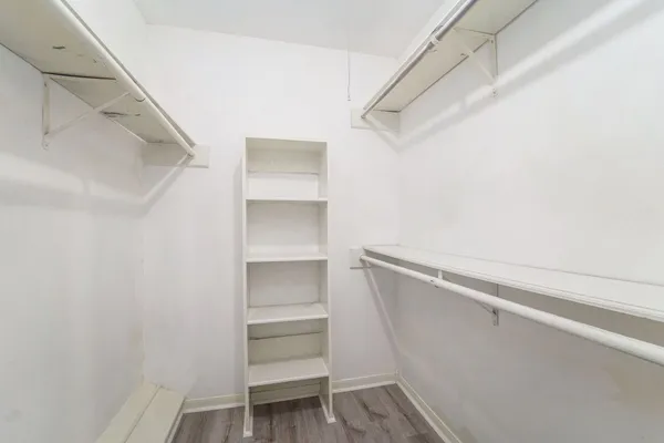 a view of walk in closet with empty racks