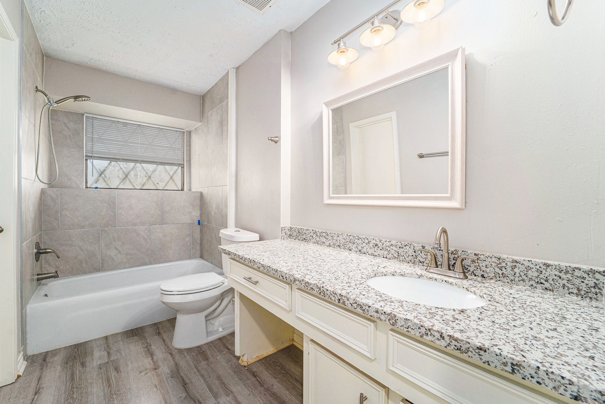 23235 Earlmist Drive Spring, TX 77373 - Photo 22 of 33 a bathroom with a granite countertop sink toilet a mirror and bathtub