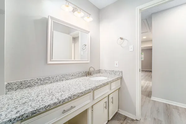 a bathroom with a granite countertop sink and a mirror