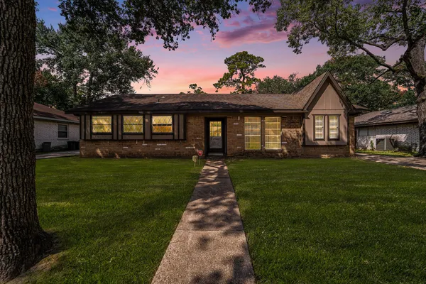 a front view of a house with a garden and yard