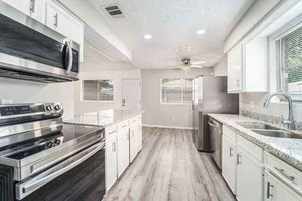 a kitchen with a sink stove and microwave